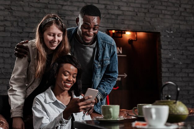 Gruppe von Freunden am Telefon lachen