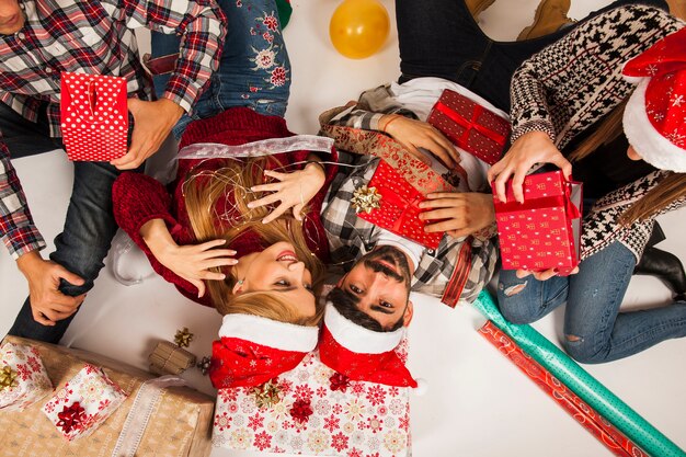 Gruppe von Freunden auf dem Boden mit Geschenken