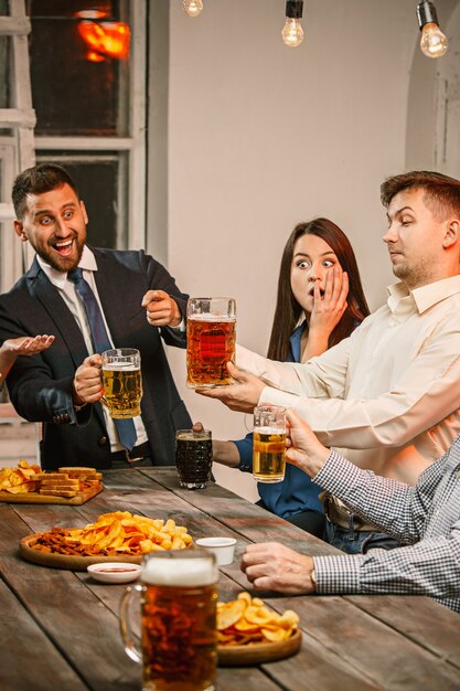 Gruppe von Freunden, die Abendgetränke mit Bier genießen