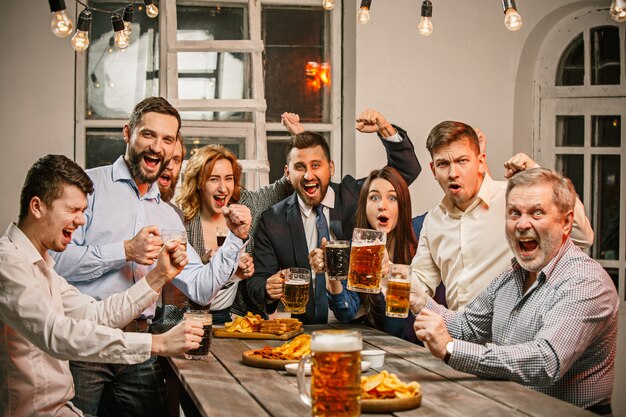 Gruppe von Freunden, die Abendgetränke mit Bier genießen