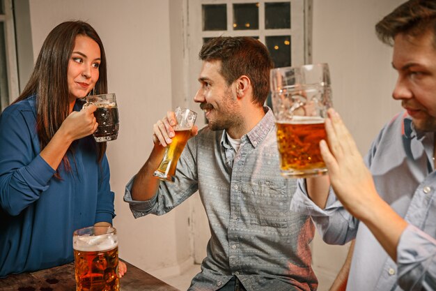 Gruppe von Freunden, die Abendgetränke mit Bier genießen