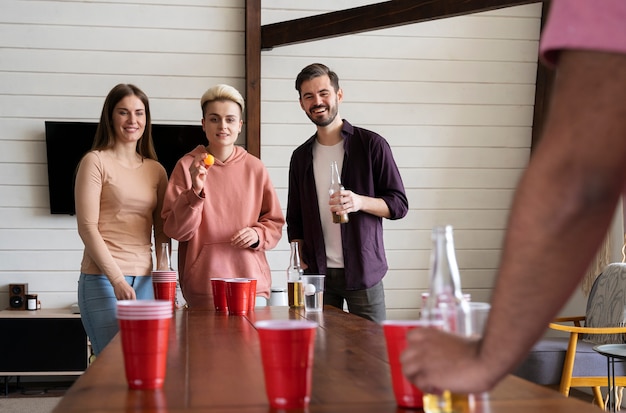 Kostenloses Foto gruppe von freunden, die auf einer party zusammen bierpong spielen