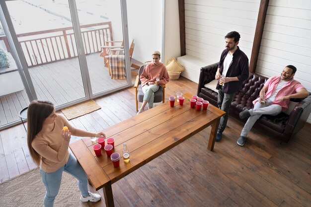 Gruppe von Freunden, die auf einer Party zusammen Bierpong spielen