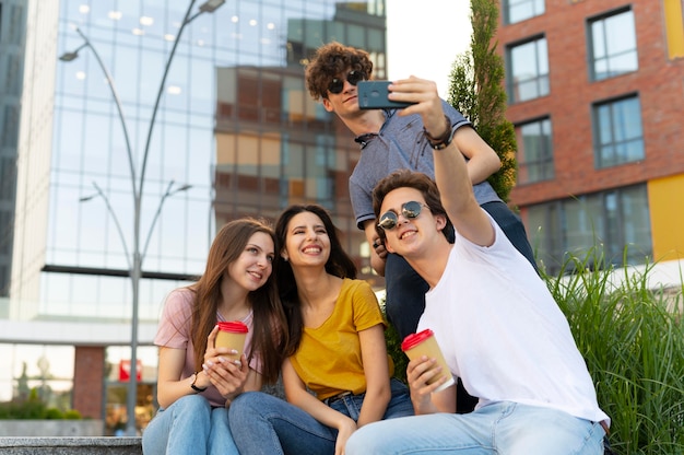 Gruppe von Freunden, die beim Kaffeetrinken im Freien ein Selfie machen