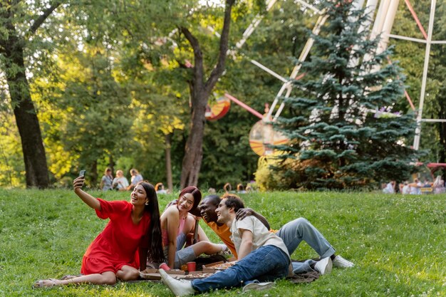 Gruppe von Freunden, die draußen am Riesenrad ein Selfie machen