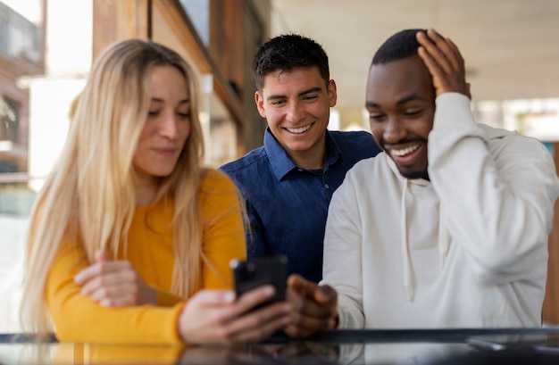 Gruppe von Freunden, die Handynachrichten lesen