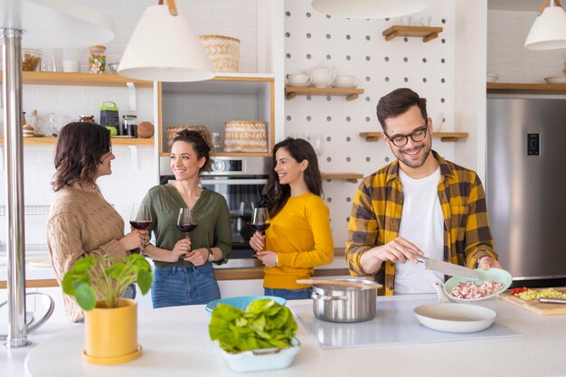 Gruppe von Freunden, die Mahlzeit in der Küche vorbereiten