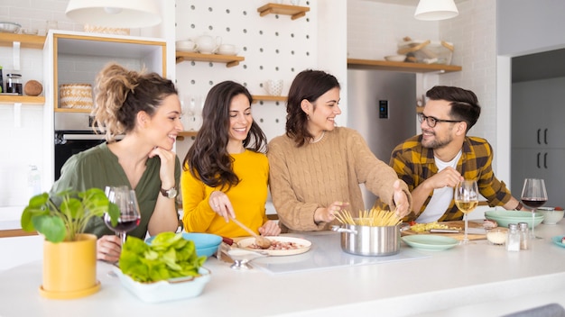 Gruppe von freunden, die mahlzeit in der küche vorbereiten