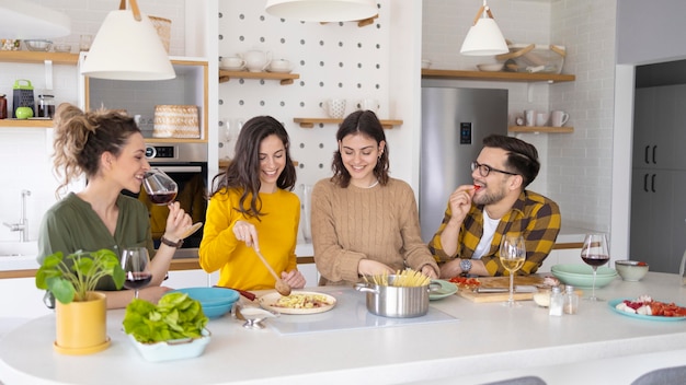 Gruppe von Freunden, die Mahlzeit in der Küche vorbereiten