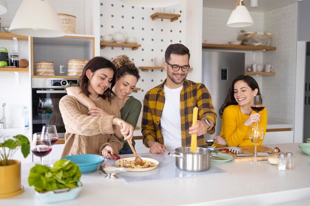 Gruppe von Freunden, die Mahlzeit in der Küche vorbereiten