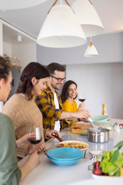 Gruppe von Freunden, die Mahlzeit in der Küche vorbereiten