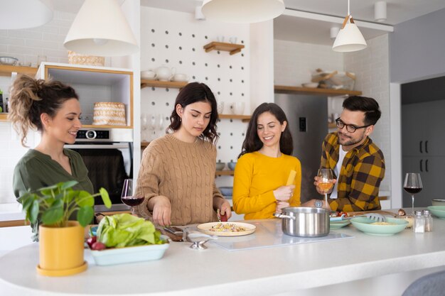 Gruppe von Freunden, die Mahlzeit in der Küche vorbereiten