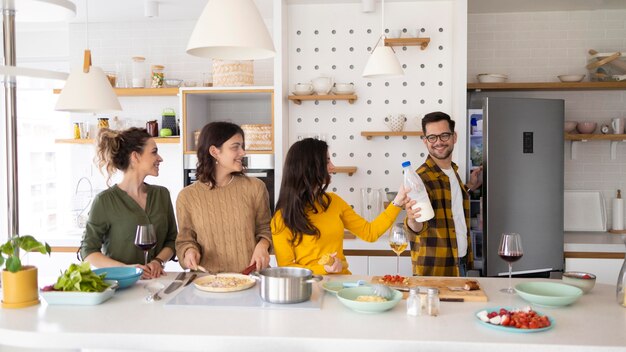 Gruppe von Freunden, die Mahlzeit in der Küche vorbereiten