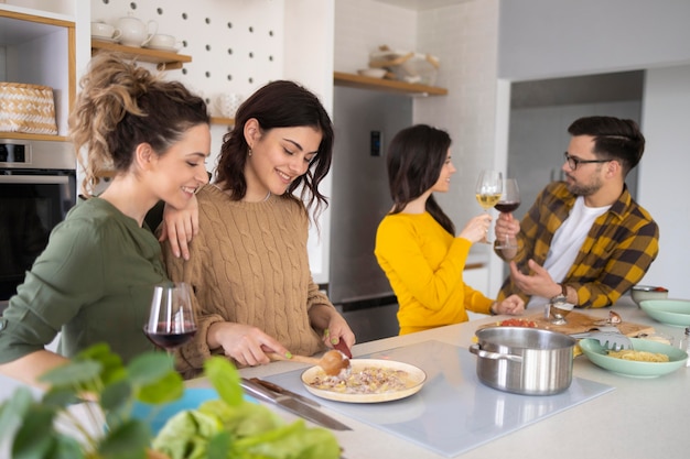 Gruppe von Freunden, die Mahlzeit in der Küche vorbereiten