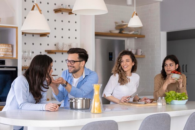 Gruppe von Freunden, die Mahlzeit in der Küche vorbereiten