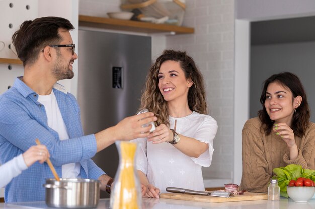 Gruppe von Freunden, die Mahlzeit in der Küche vorbereiten