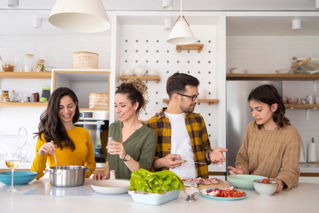 Gruppe von Freunden, die Mahlzeit in der Küche vorbereiten