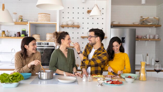 Gruppe von Freunden, die Mahlzeit in der Küche vorbereiten