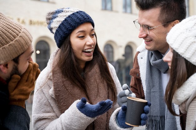 Gruppe von Freunden, die sich bei einer Tasse Kaffee im Freien unterhalten