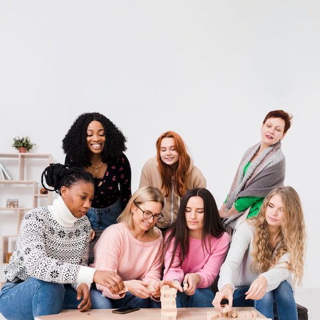 Gruppe von Freunden, die zusammen ein Holzturmspiel spielen