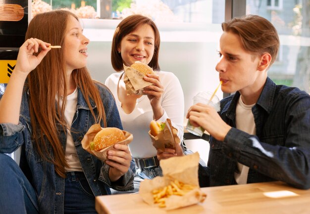 Gruppe von Freunden, die zusammen Fast Food essen