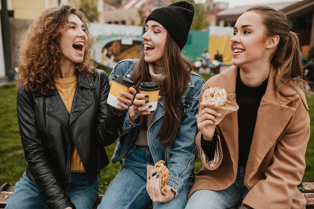 Kostenloses Foto gruppe von freunden, die zusammen süßigkeiten genießen