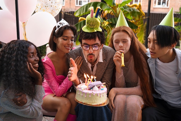 Gruppe von Freunden mit Kuchen auf einer Überraschungsgeburtstagsfeier