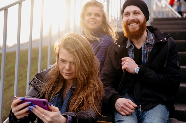 Gruppe von Freunden mit Smartphone auf Treppen