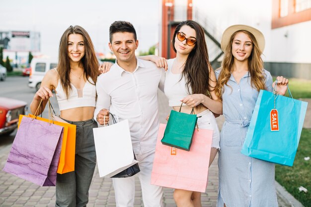 Gruppe von Freunden posiert mit Papiertüten