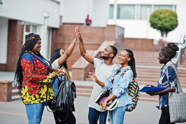 Gruppe von fünf afrikanischen College-Studenten, die Zeit miteinander auf dem Campus des Universitätshofs verbringen Schwarze Afro-Freunde studieren und geben sich gegenseitig High Five