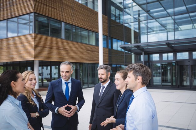 Gruppe von Geschäftsleuten, die außerhalb des Bürogebäudes interagieren