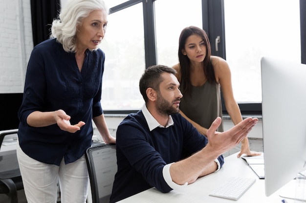 Gruppe von Geschäftsleuten, die Finanzplan am Tisch in einem Büro besprechen