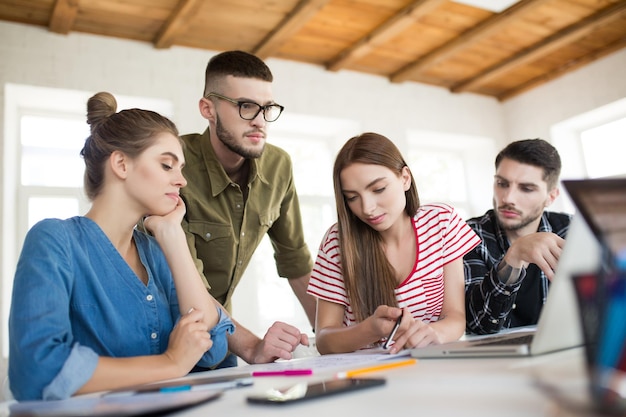 Kostenloses Foto gruppe von geschäftsleuten und -frauen, die nachdenklich mit laptops arbeiten, während sie zeit bei der arbeit verbringen junge kreative menschen diskutieren über die zusammenarbeit im modernen büro