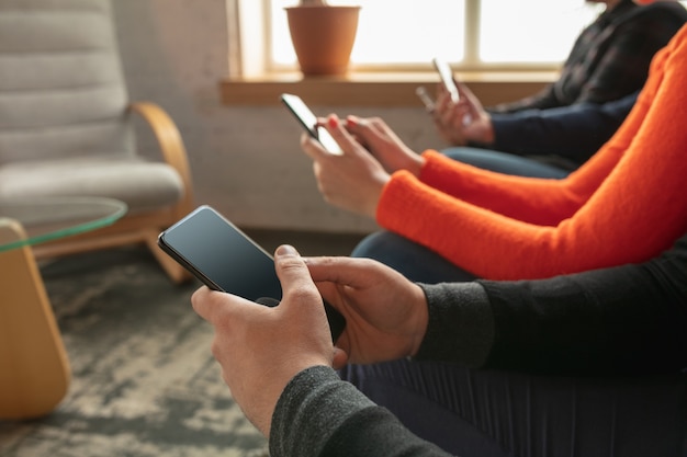 Gruppe von glücklichen jungen jungen Leuten, die zusammen auf einem Sofa sitzen.