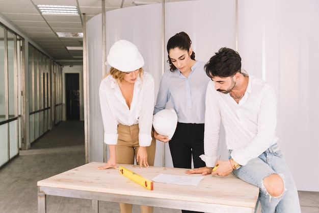 Gruppe von Ingenieuren über Tisch gelehnt