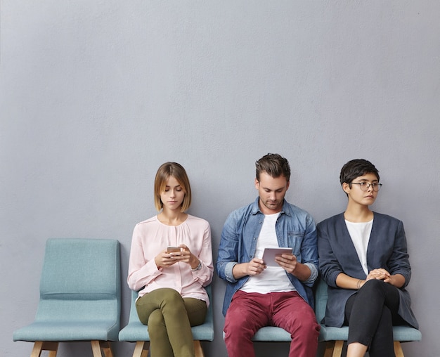 Gruppe von Leuten, die im Wartezimmer sitzen