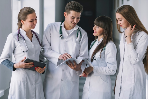 Gruppe von Medizinern mit Papieren in der Klinik