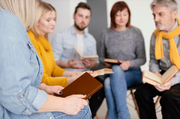 Gruppe von Menschen, die Bücher bei der Therapiesitzung lesen