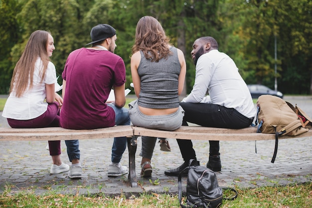 Kostenloses Foto gruppe von menschen sitzen auf bank draußen