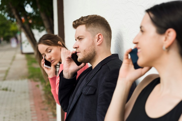 Gruppe von Personen, die draußen an den Telefonen spricht