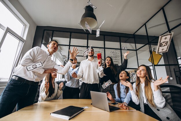 Gruppe von Personen, die Geld in ein Büro wirft