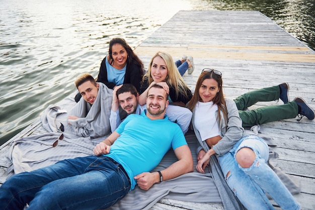 Gruppe von schönen jungen Menschen auf dem Pier, Freunde Zufriedenheit schafft emotionales Leben.