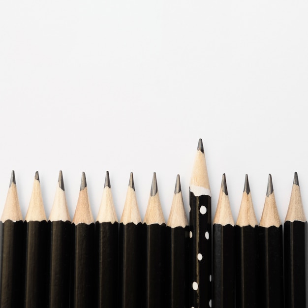 Gruppe von schwarzen Stiften und einem Bleistift mit Punkten