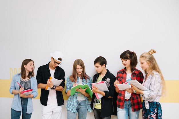 Gruppe von Studenten posiert mit Notizblöcken