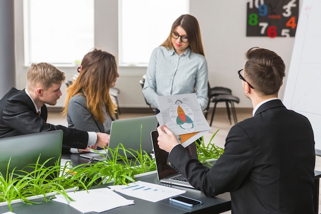 Gruppe Wirtschaftler, die Diagramm am Arbeitsplatz analysieren