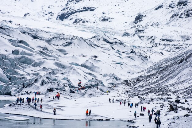 Gruppen von Wandertouristen, die in den schneeweißen schroffen Bergen wandern