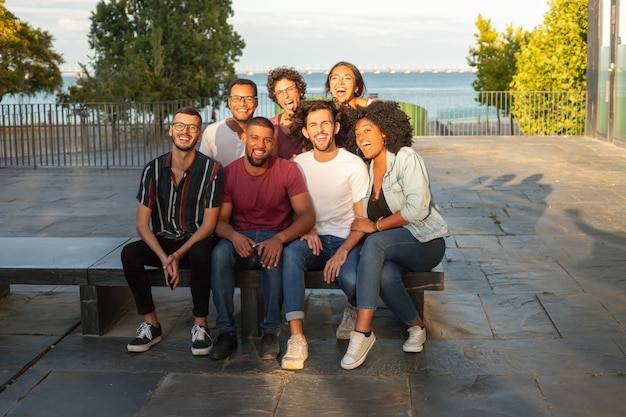 Gruppenporträt von netten glücklichen multiethnischen Männern und von Frauen
