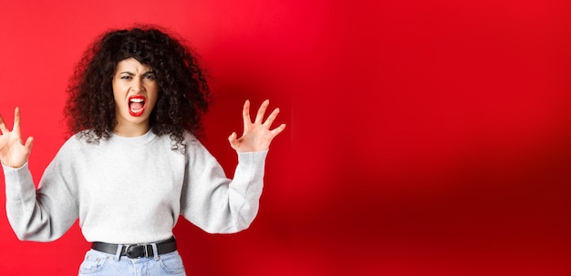 Kostenloses Foto gruselige frau, die versucht, dich zu erschrecken, indem sie schreit und tierklauen zeigt, die auf personenstandi schreien