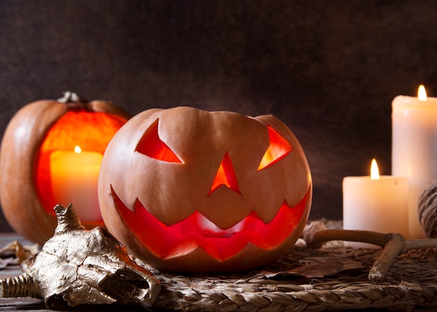 Gruselige geschnitzte Halloween-Kürbislaterne mit brennenden Kerzen