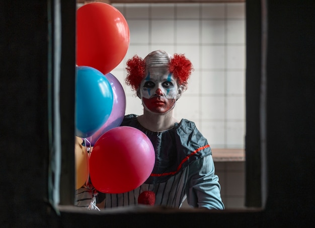 Kostenloses Foto gruseliger clown der vorderansicht in verlassenem gebäude